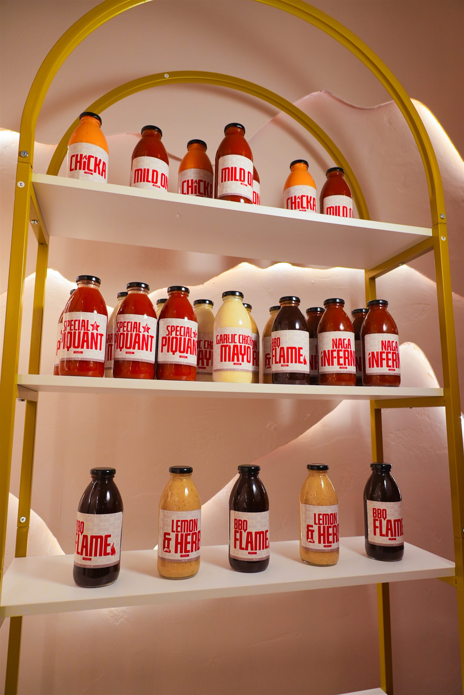 Chickaros signature sauce bottles on gold display